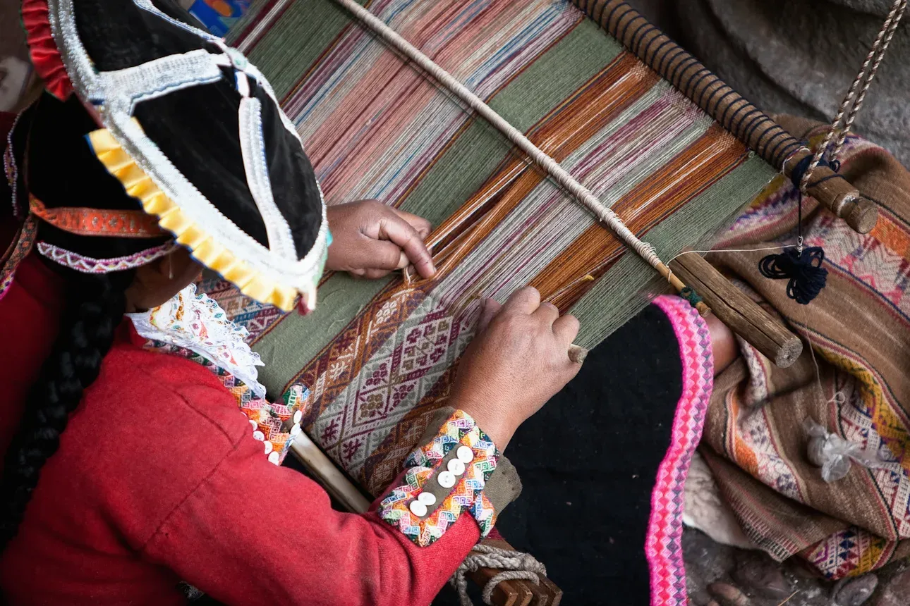 A weaver in Cusco working patterned cloth on a backstrap loom